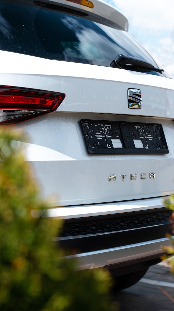 Detailed close-up of the rear of a parked white Seat Ateca SUV with emblem visible.