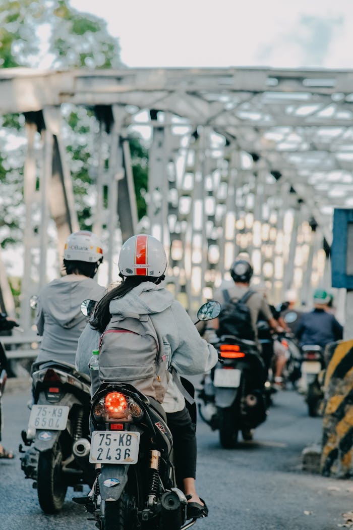 gallery-1 Group of people riding motorcycles on a bridge, highlighting daily commute.