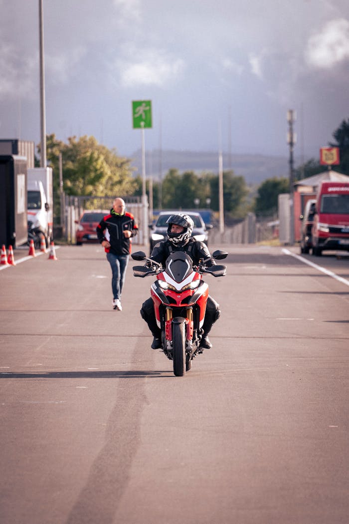 gallery-5 Motorcyclist in gear riding a Ducati bike at Nürburgring racetrack with clear skies.