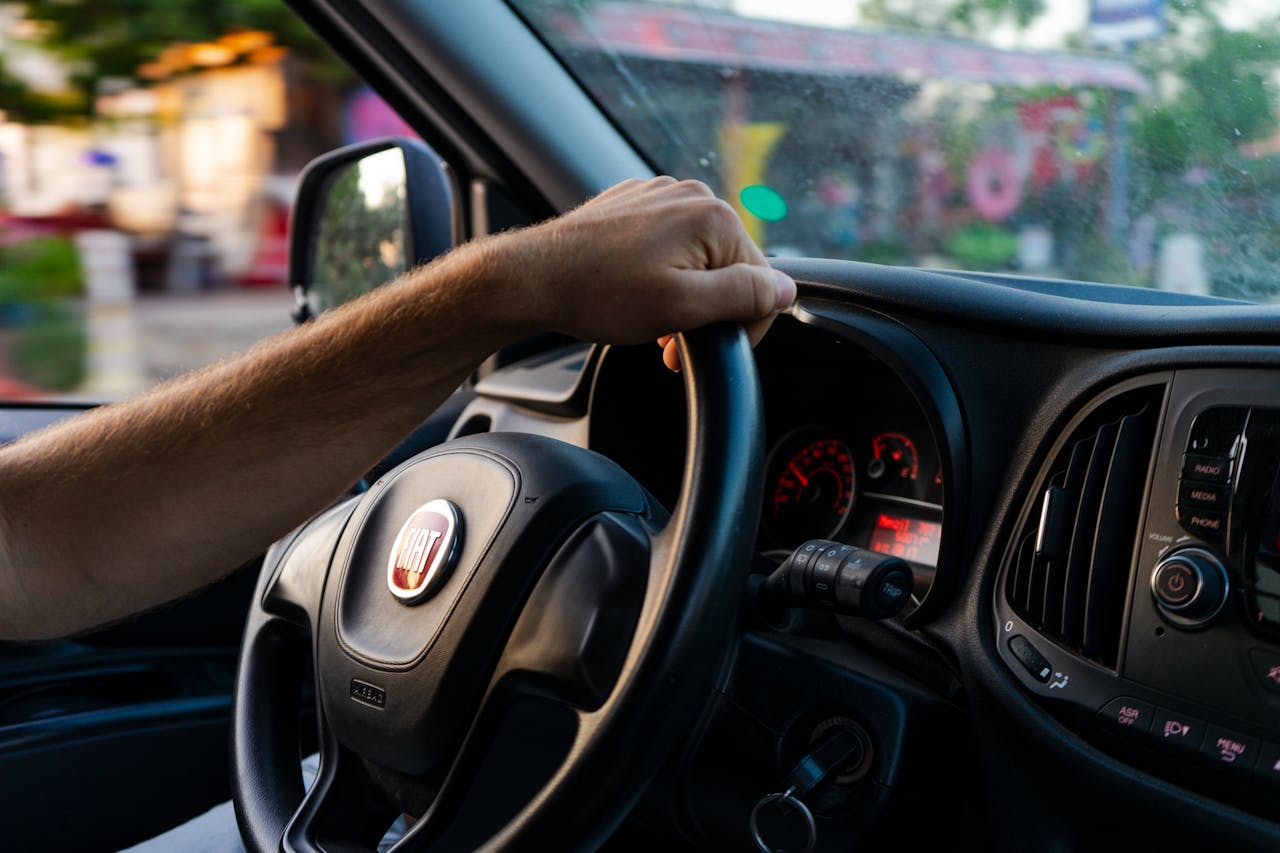 services-02 Close-up of a hand on a Fiat steering wheel while driving in Fethiye, Türkiye.